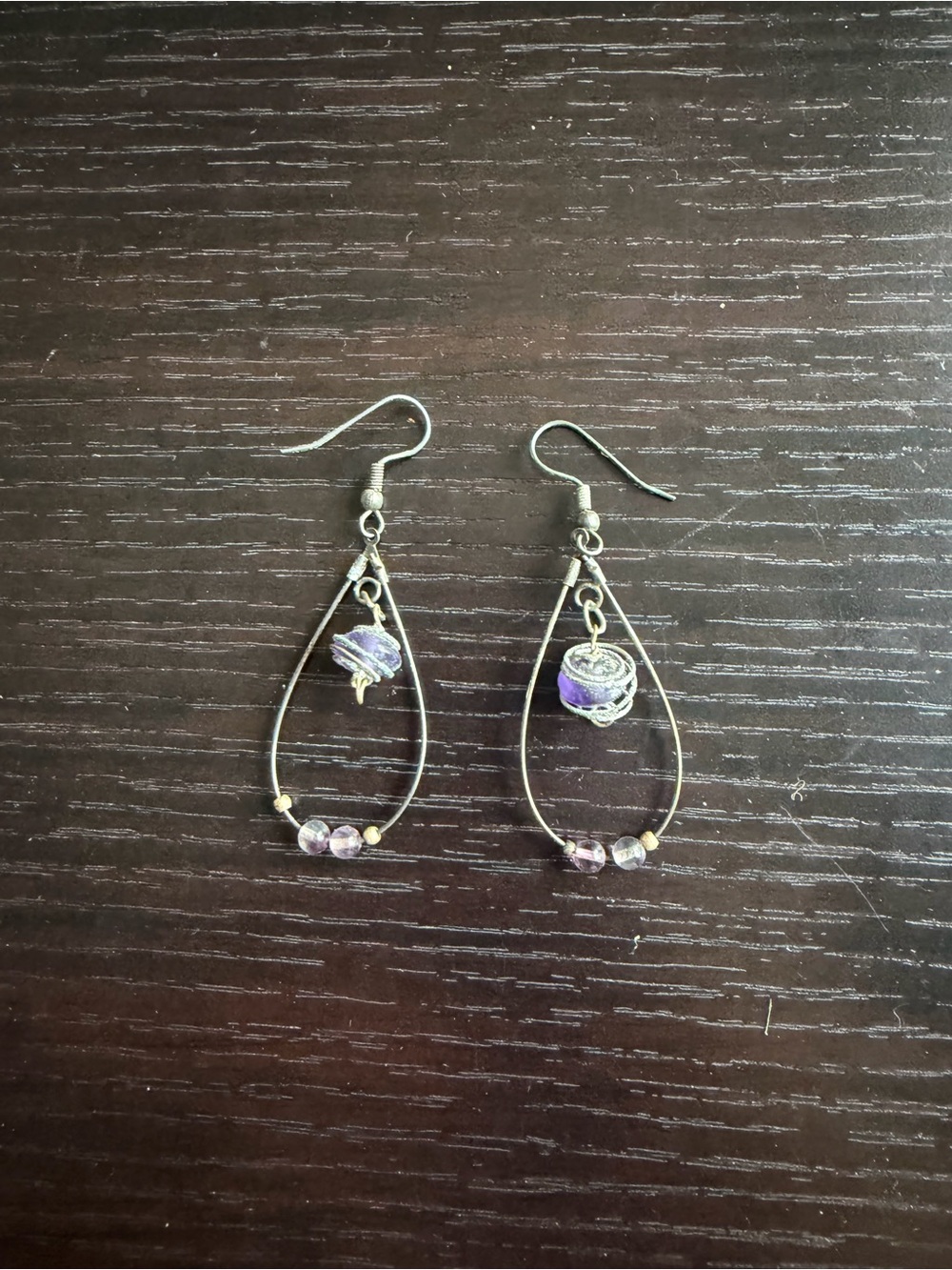 Wire-wrapped teardrop hoop earrings featuring a dangling purple gemstone bead